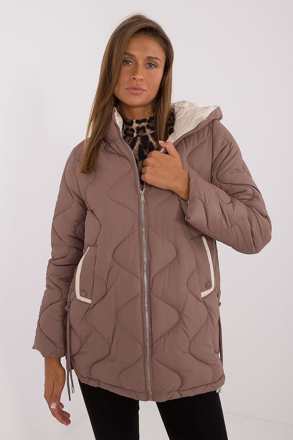 Woman wearing a quilted jacket with a white background