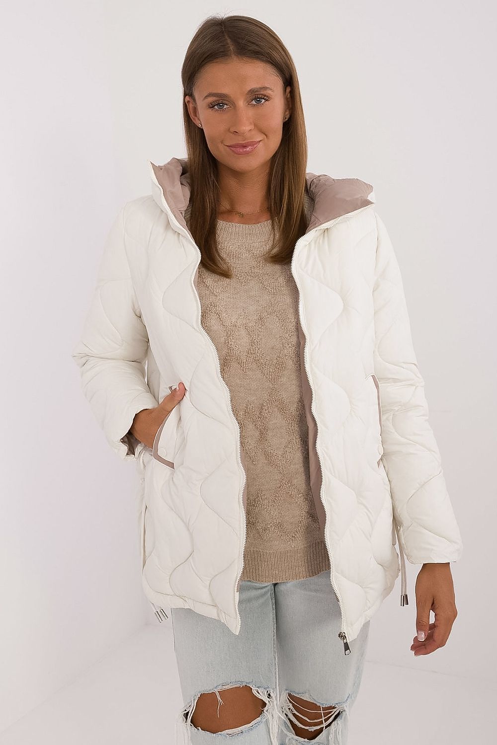 Woman wearing a white puffer jacket with a gray hood on a white background