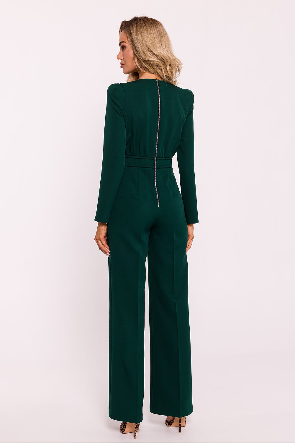 Green jumpsuit worn by a model on a white background