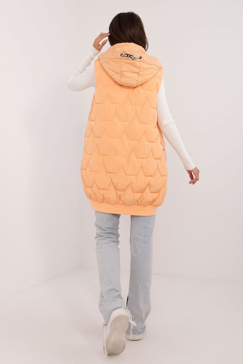  Model wearing orange padded women’s vest, knee-length
