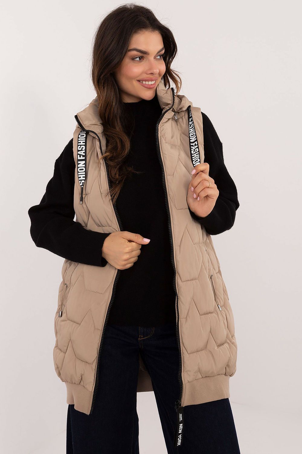 Woman wearing a beige quilted vest with brand logo on a white background
