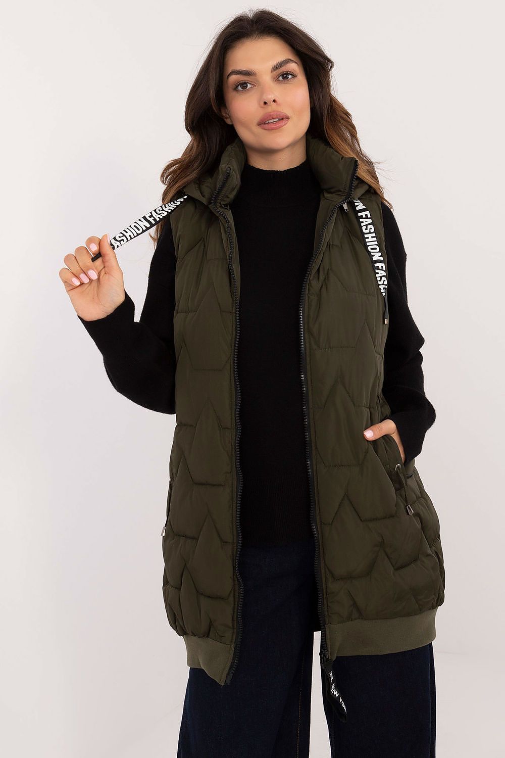 Woman wearing a green puffer vest with a brand logo on a white background