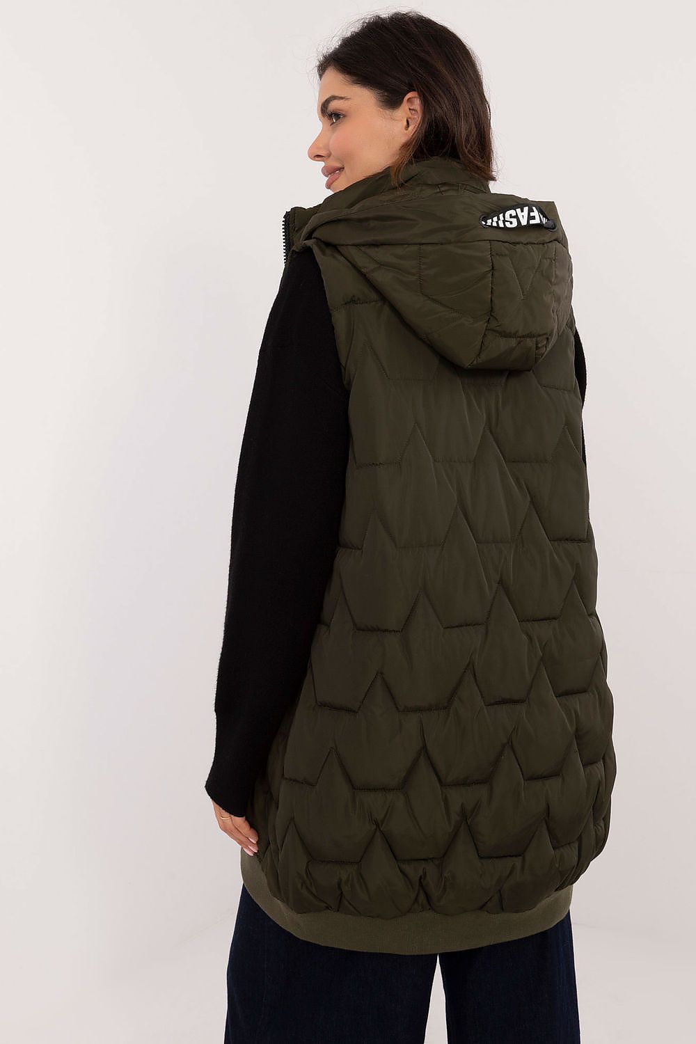 Woman wearing a green quilted jacket with a hood on a white background
