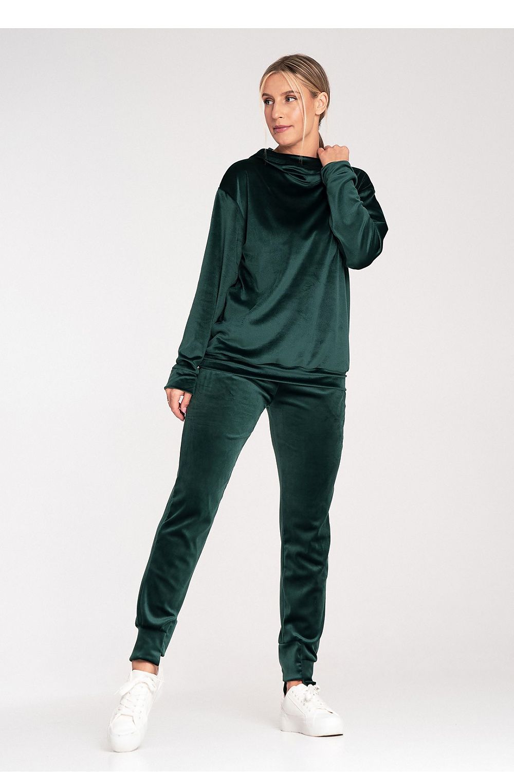 Woman wearing a green tracksuit on a white background