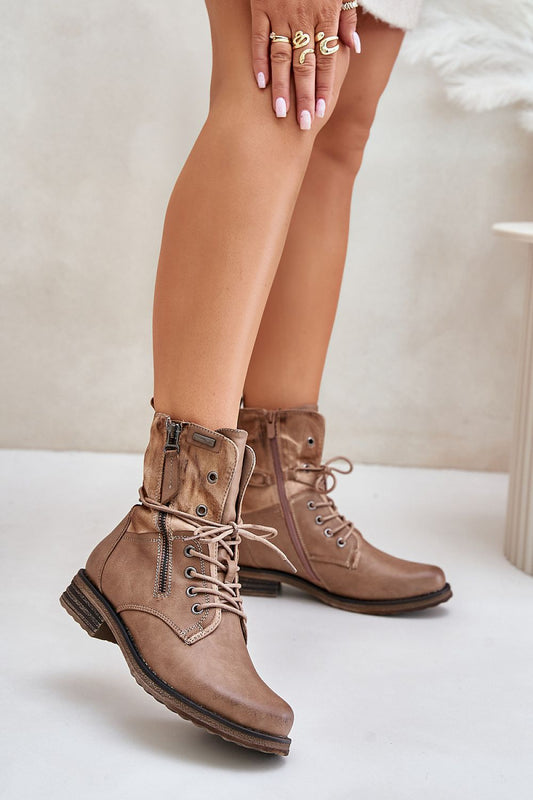 Close-up of natural leather flat boots highlighting stitching, lace-up detail, and warm interior.