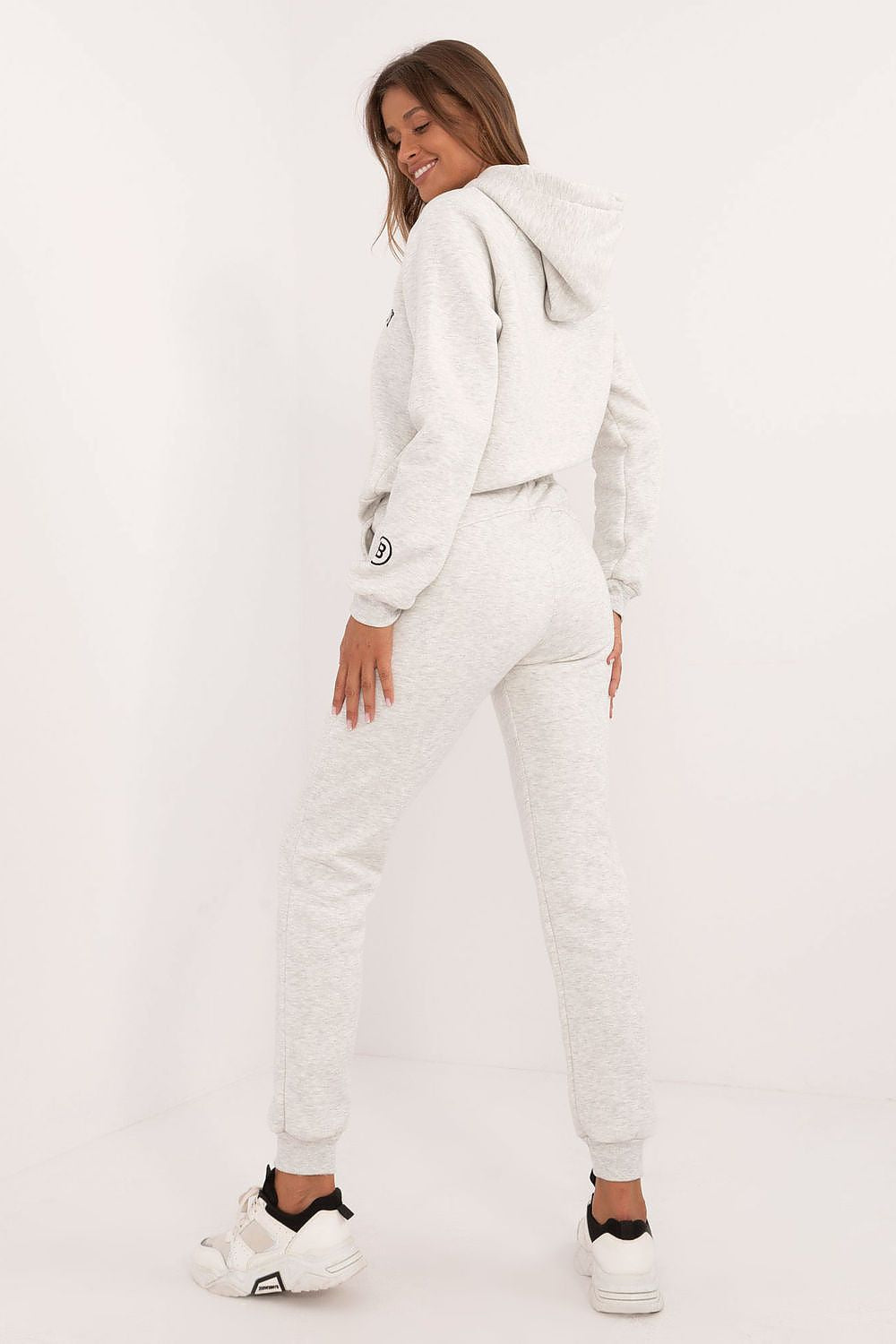 Woman wearing a white tracksuit on a white background
