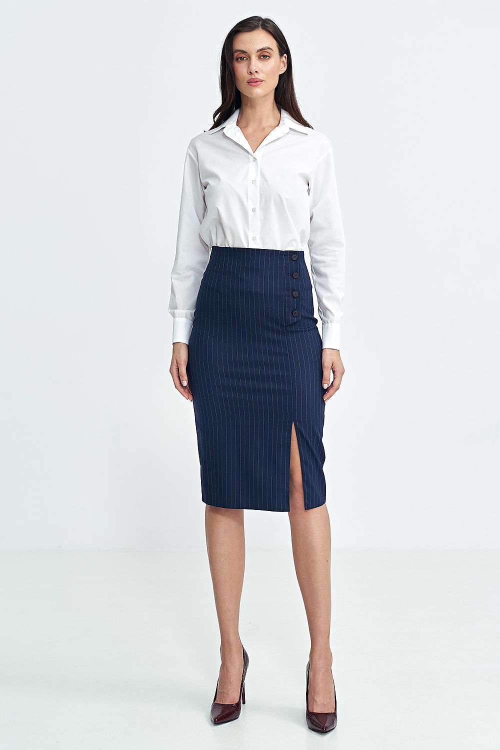 Woman wearing a white blouse and navy skirt on a white background