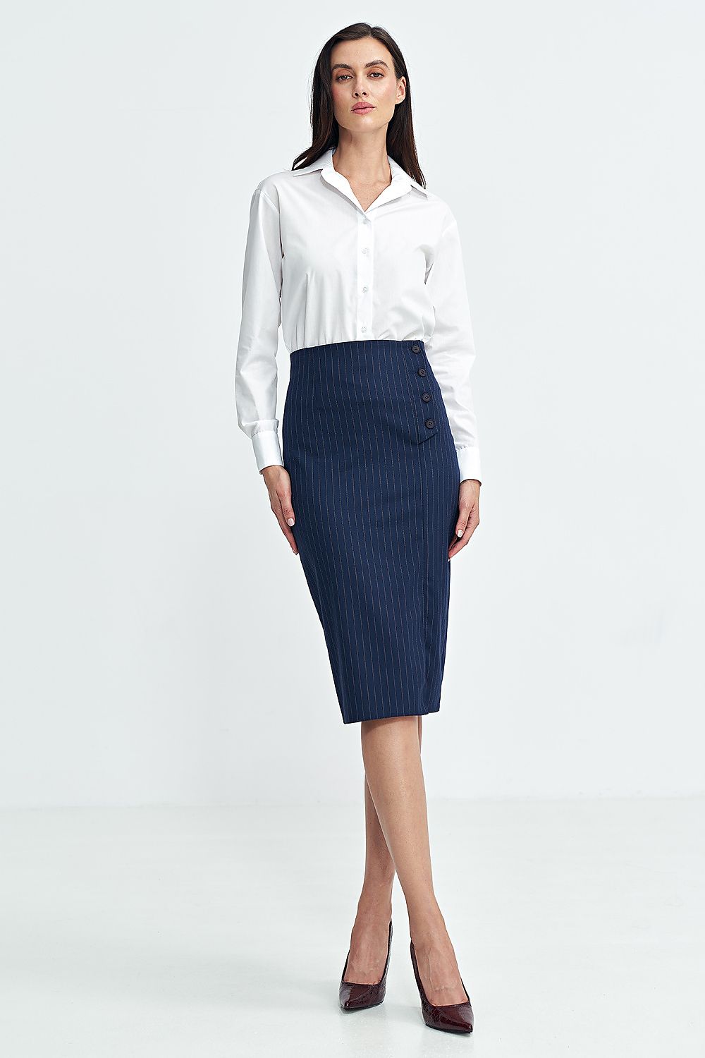 Woman wearing a white shirt and navy pinstripe skirt on a white background