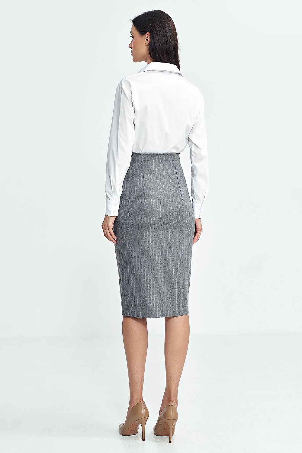 Woman wearing a white shirt and gray checkered skirt on a white background