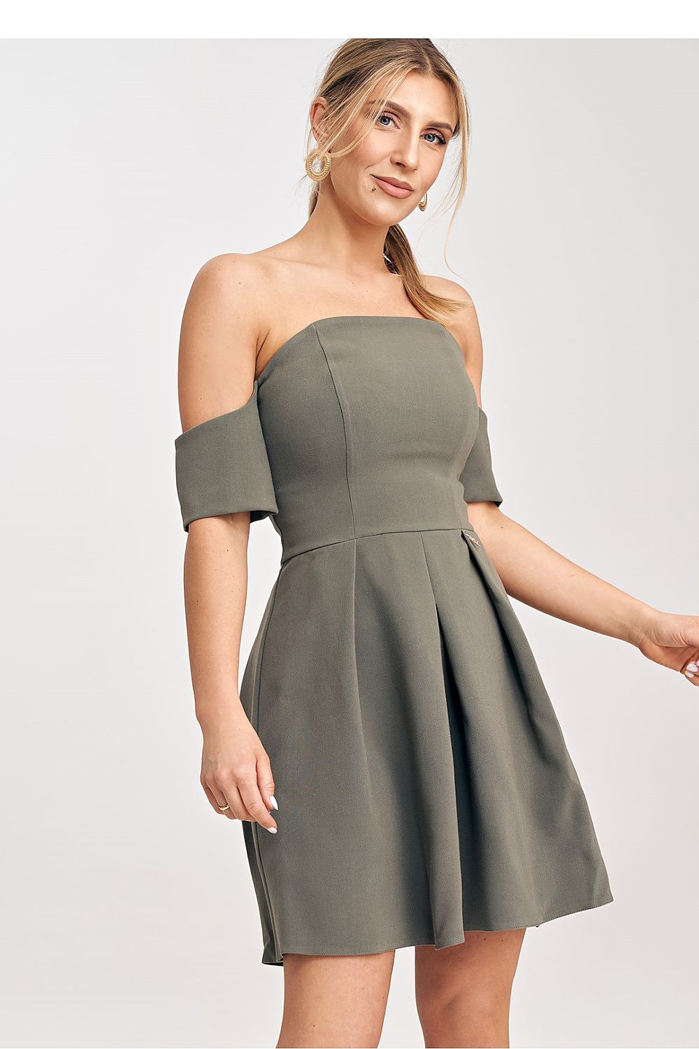 Woman wearing a green off-shoulder dress on a white background