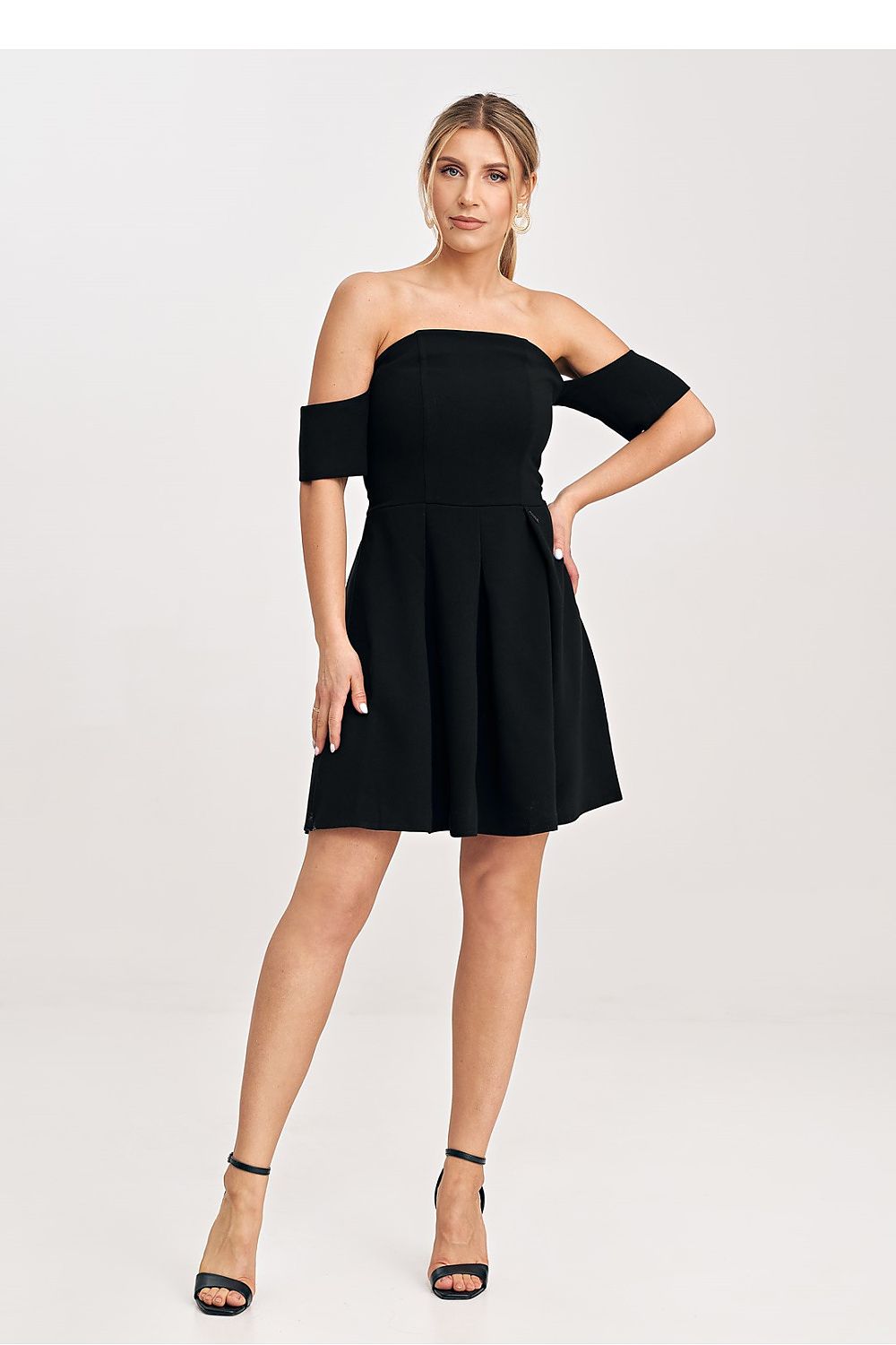 Woman wearing a black off-shoulder dress on a white background