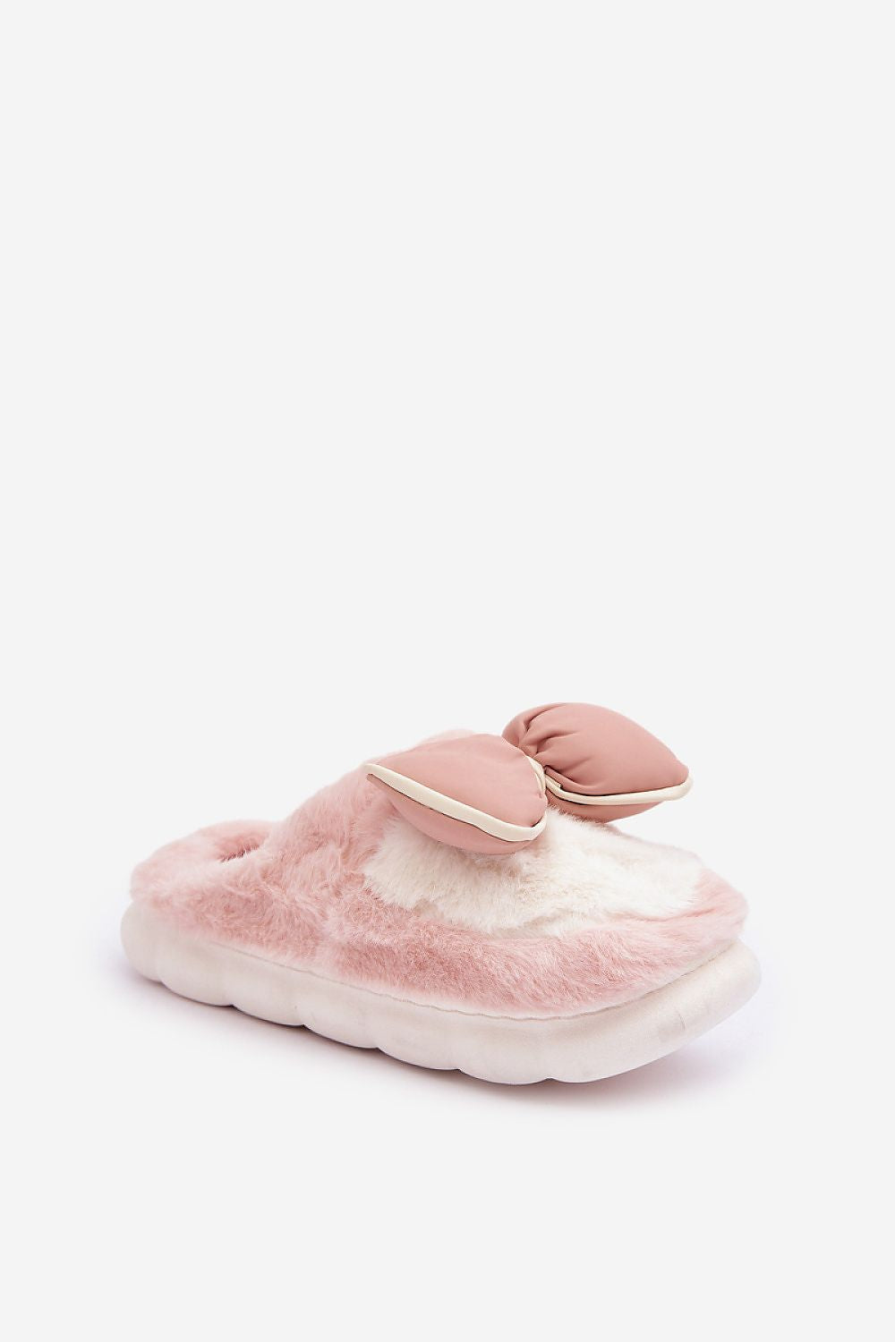 Pink fuzzy slippers with bow detail on a white background
