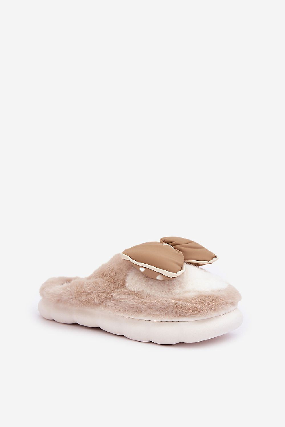 Beige fuzzy slippers with a bow on a white background
