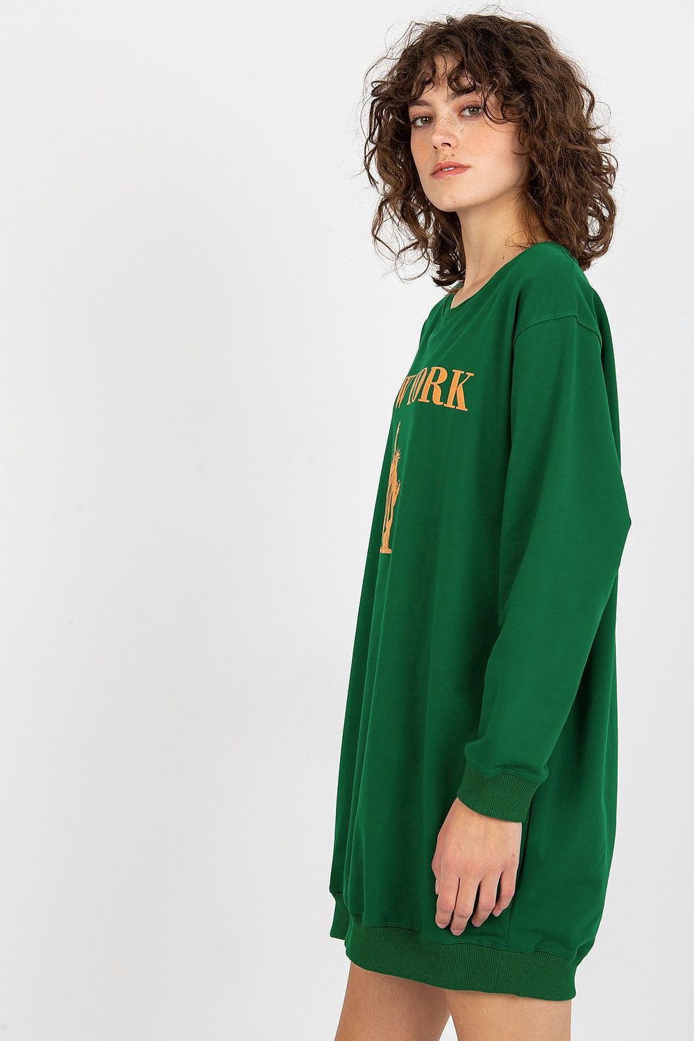 Person wearing a green oversized sweatshirt with 'New York' print on a white background