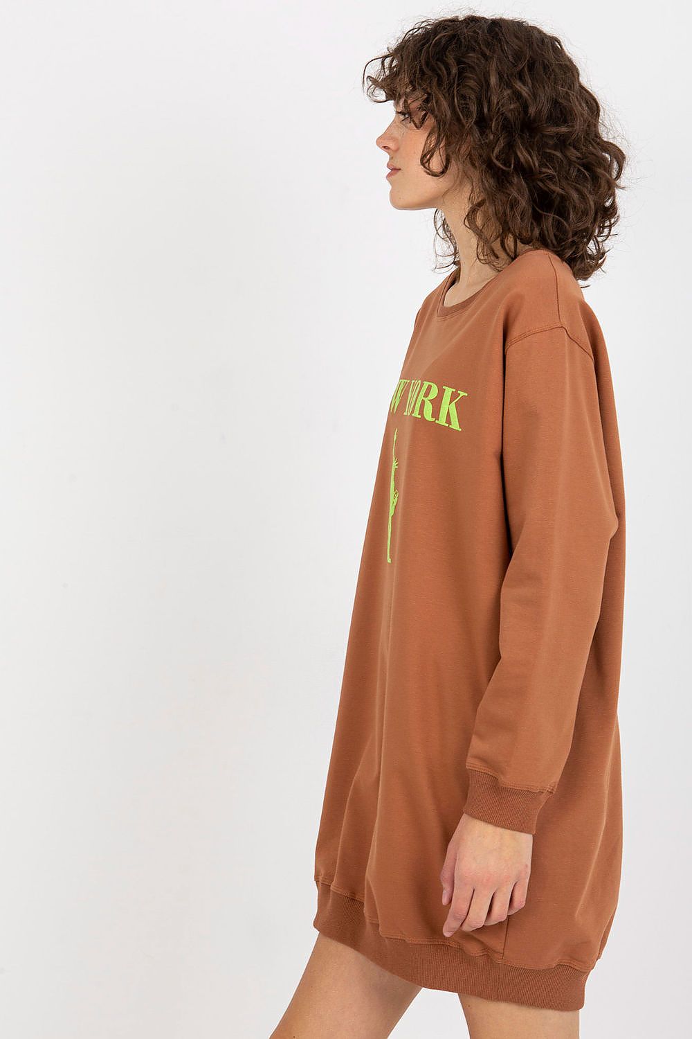 Person wearing a brown sweatshirt dress with 'NYRK' text on a white background