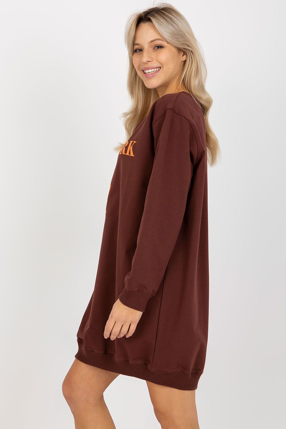 Woman wearing a brown sweatshirt dress with 'ARK' logo on a white background
