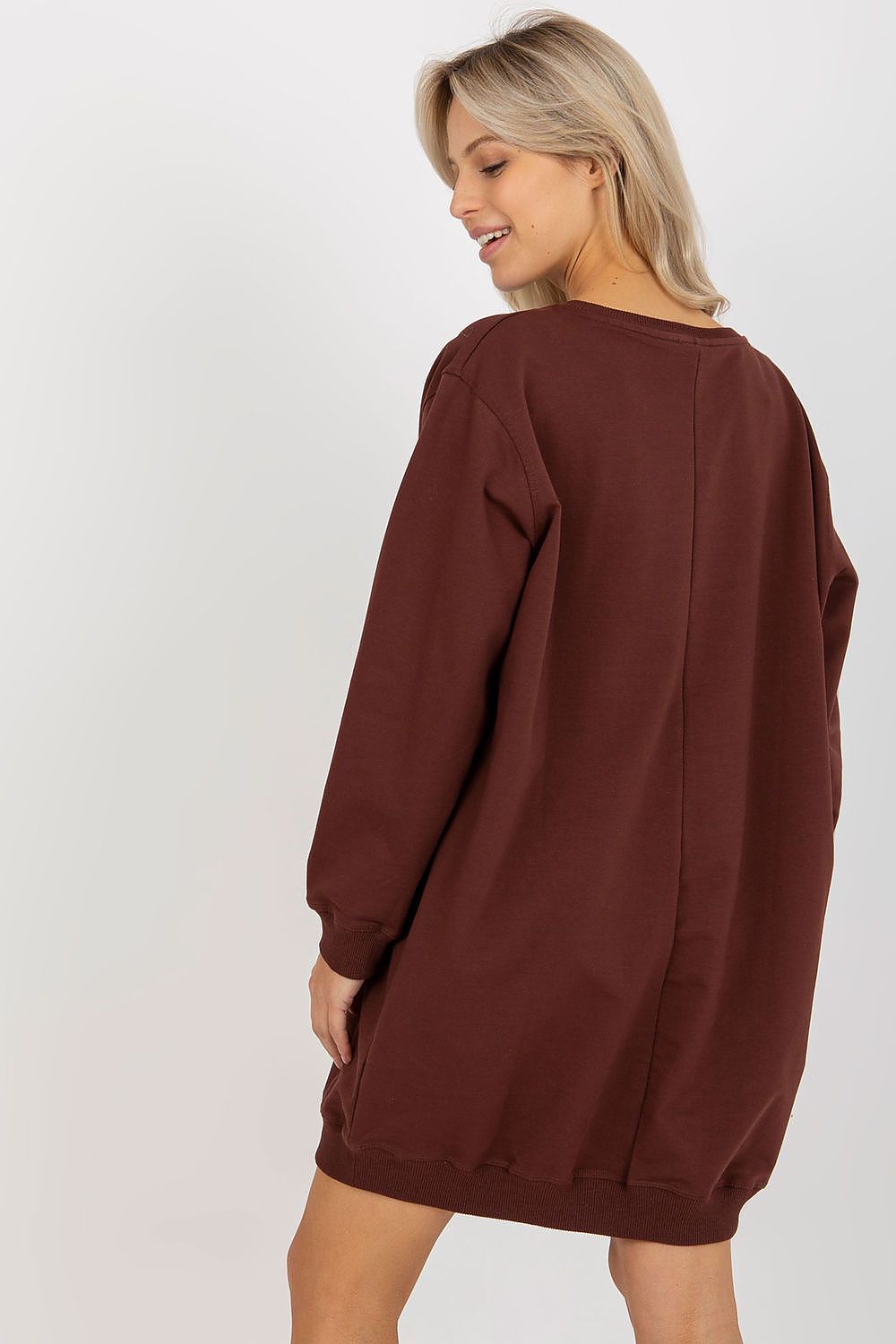 Person wearing a brown sweatshirt dress on a white background