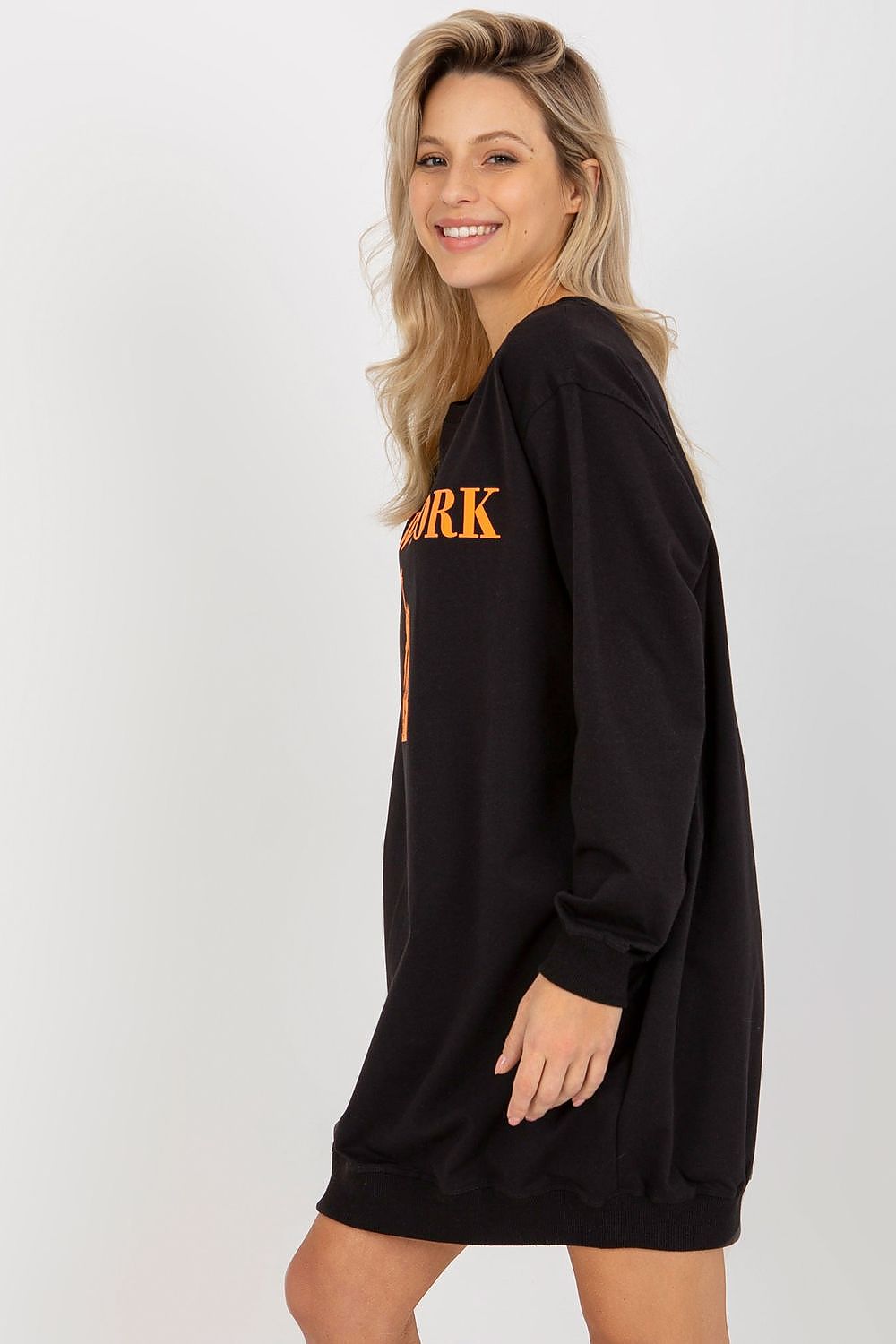 Woman wearing a black long-sleeve dress with 'N.Y.K.' text on a white background