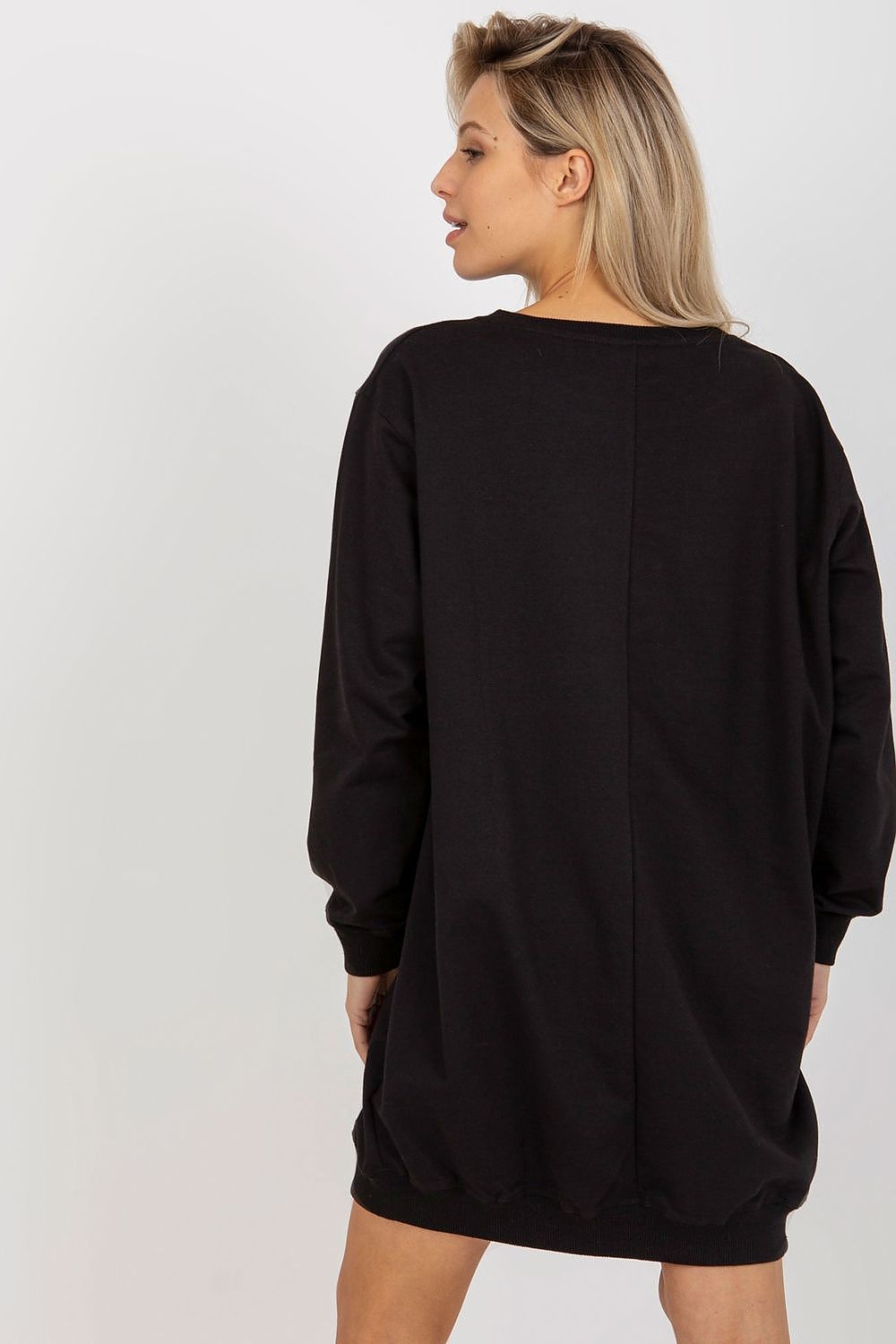 Person wearing a black oversized sweatshirt dress on a white background
