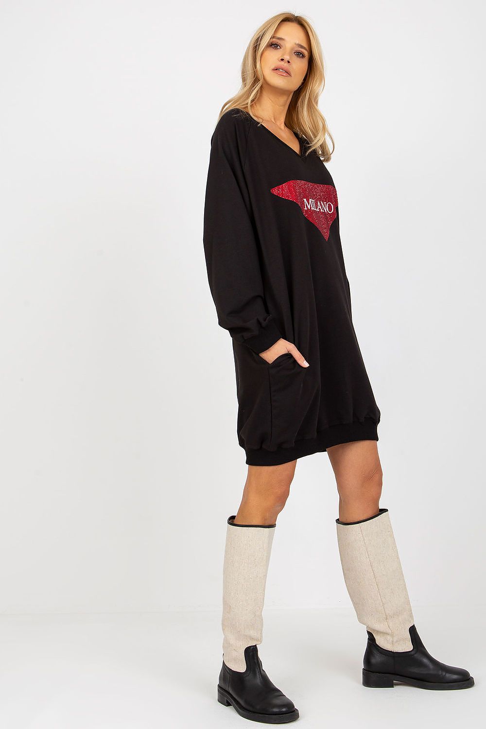 Woman wearing a black dress with a red logo and knee-high white socks on a white background