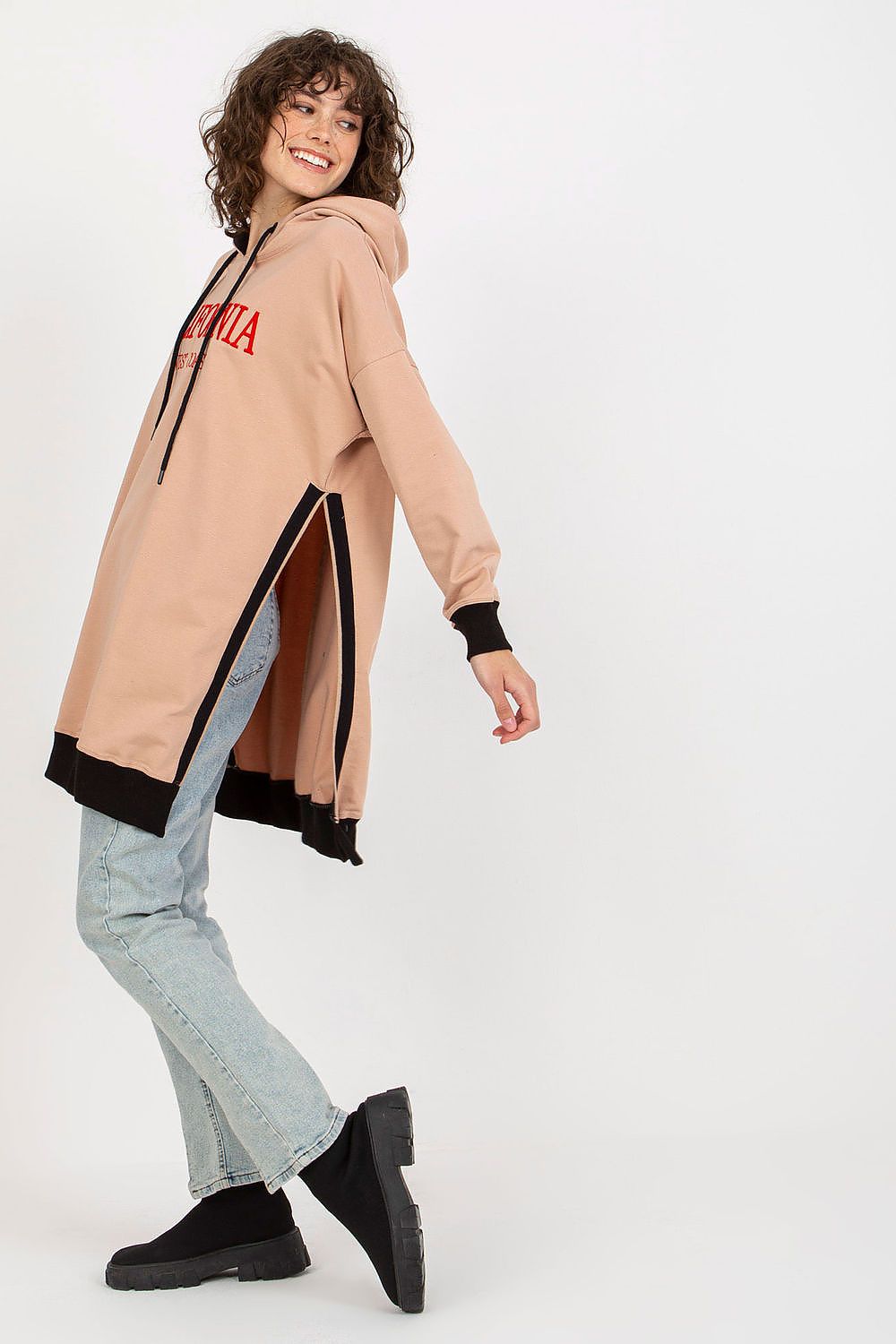 Woman wearing a beige hooded coat with black accents on a white background