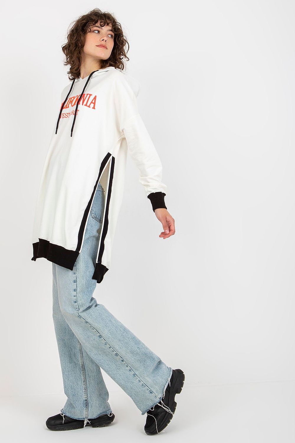 Person wearing a white hoodie with text, black and white striped pants, and light blue jeans on a white background
