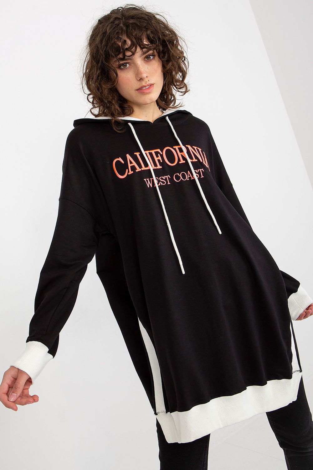 Woman wearing a black hoodie with 'California West Coast' text on a white background