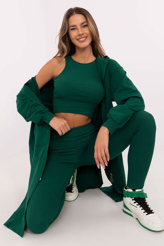 Woman wearing a green outfit with a matching coat on a white background