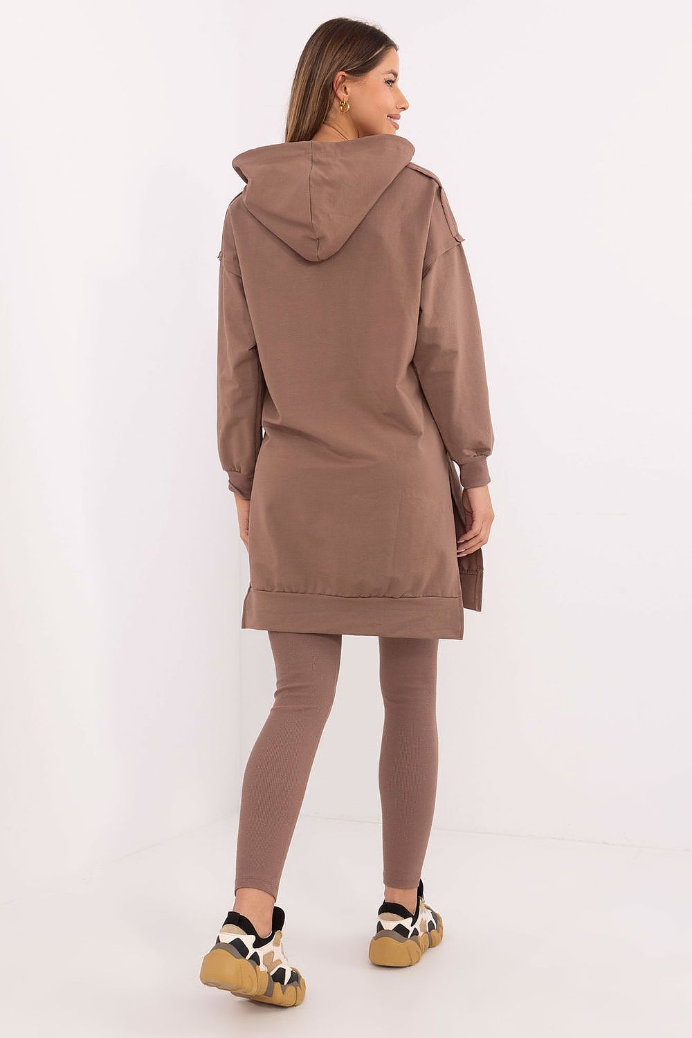  Model showcasing light beige outfit in relaxed pose.