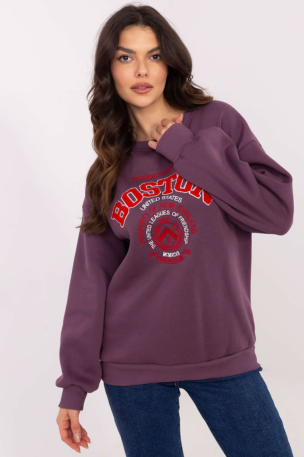 Woman wearing a purple sweatshirt with red text and graphics on a white background