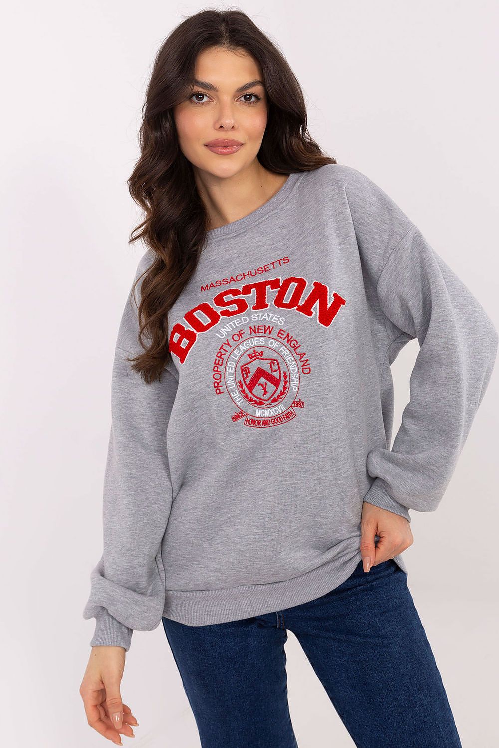 Woman wearing a gray sweatshirt with 'Boston' print on a white background