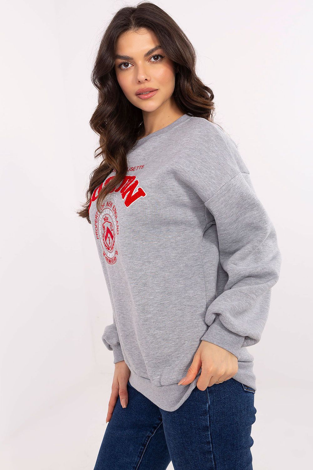 Woman wearing a gray sweatshirt with red text and logo on a white background
