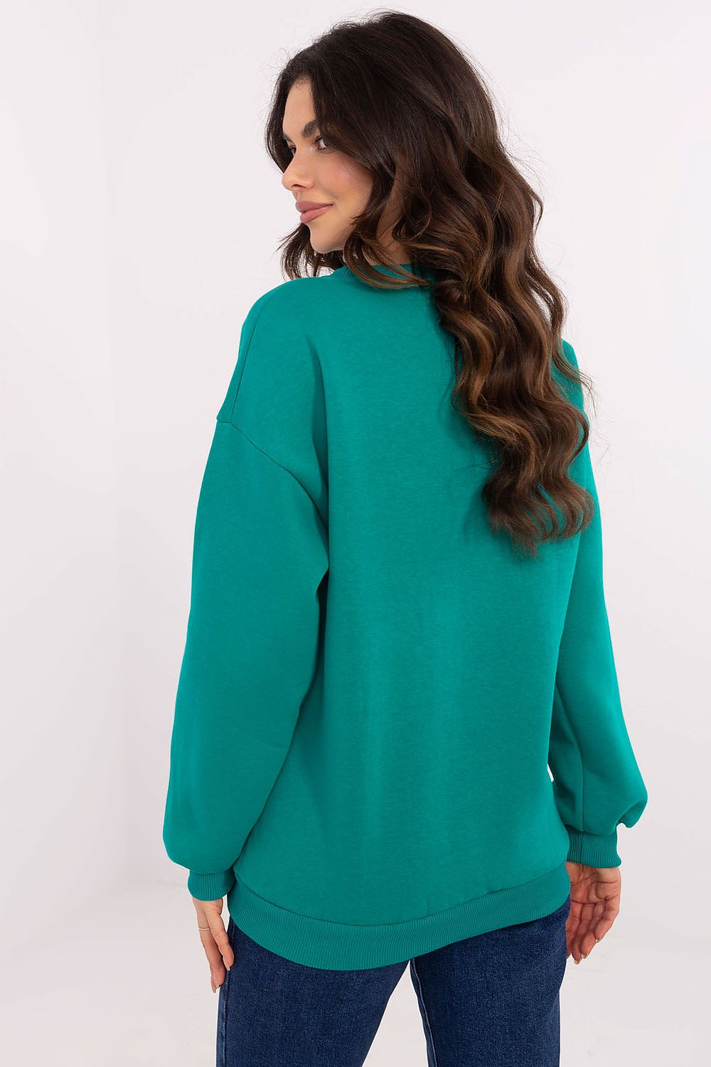 Woman wearing a teal sweater on a white background