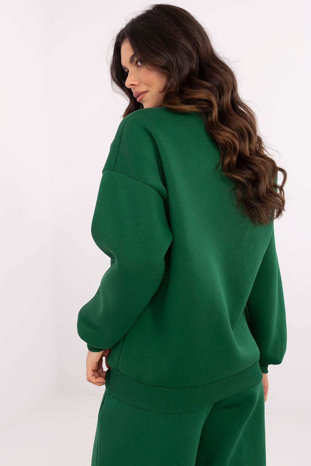 Woman wearing a green tracksuit against a white background