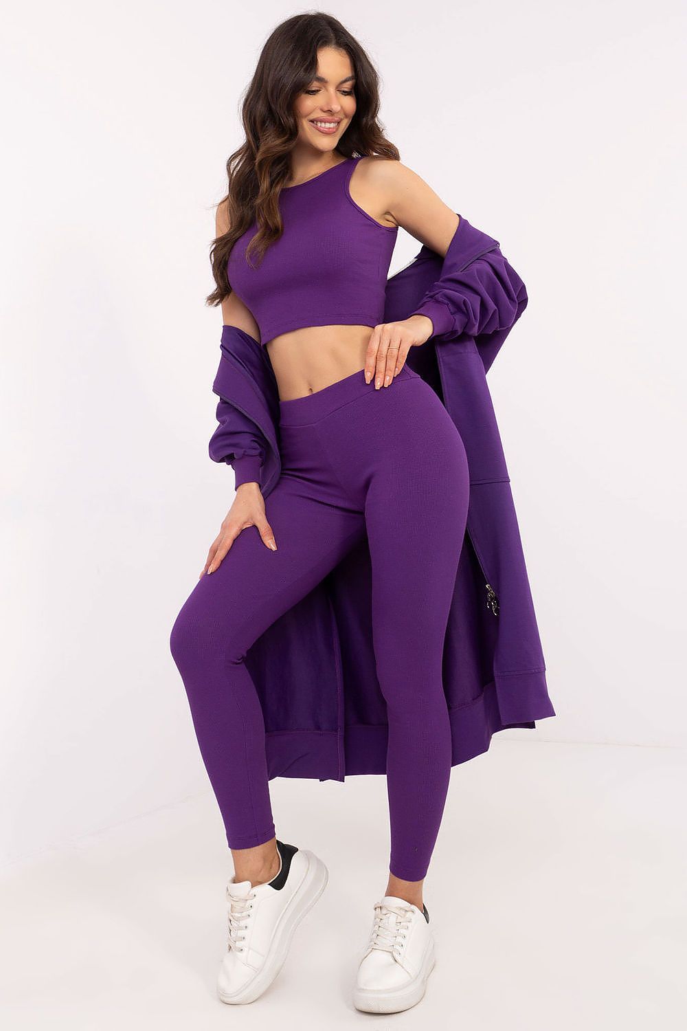 Woman wearing a purple outfit with a long cardigan on a white background