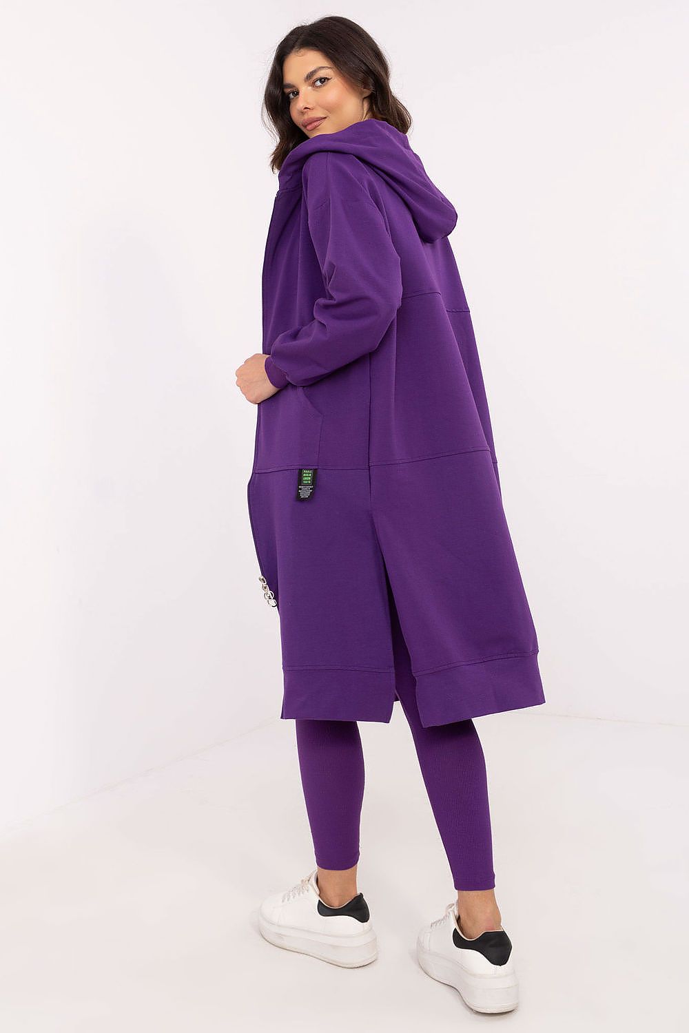 Woman wearing a purple tracksuit on a white background