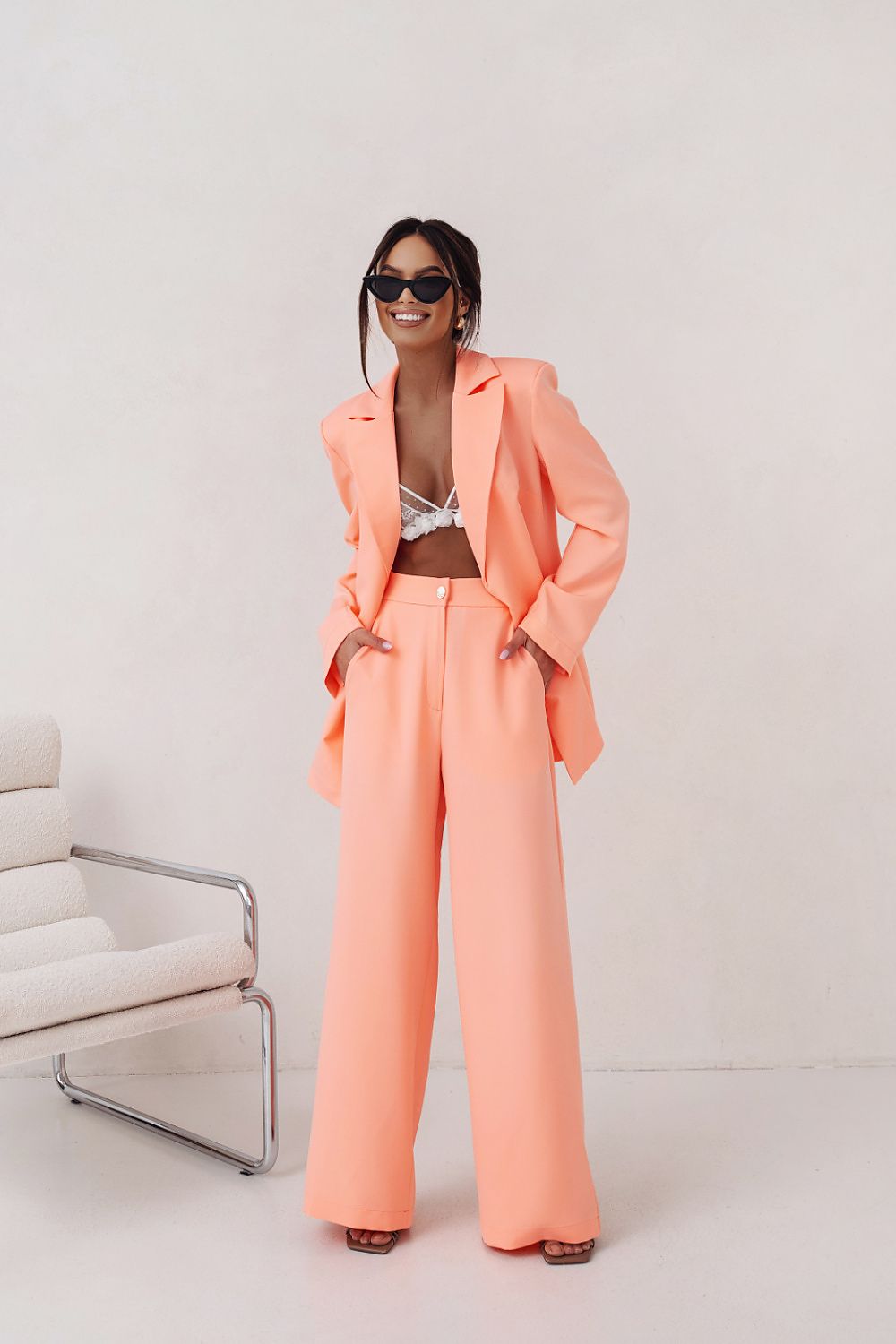  Elegant women’s tailored suit in orange, showing modern tailoring and sleek, polished structure.