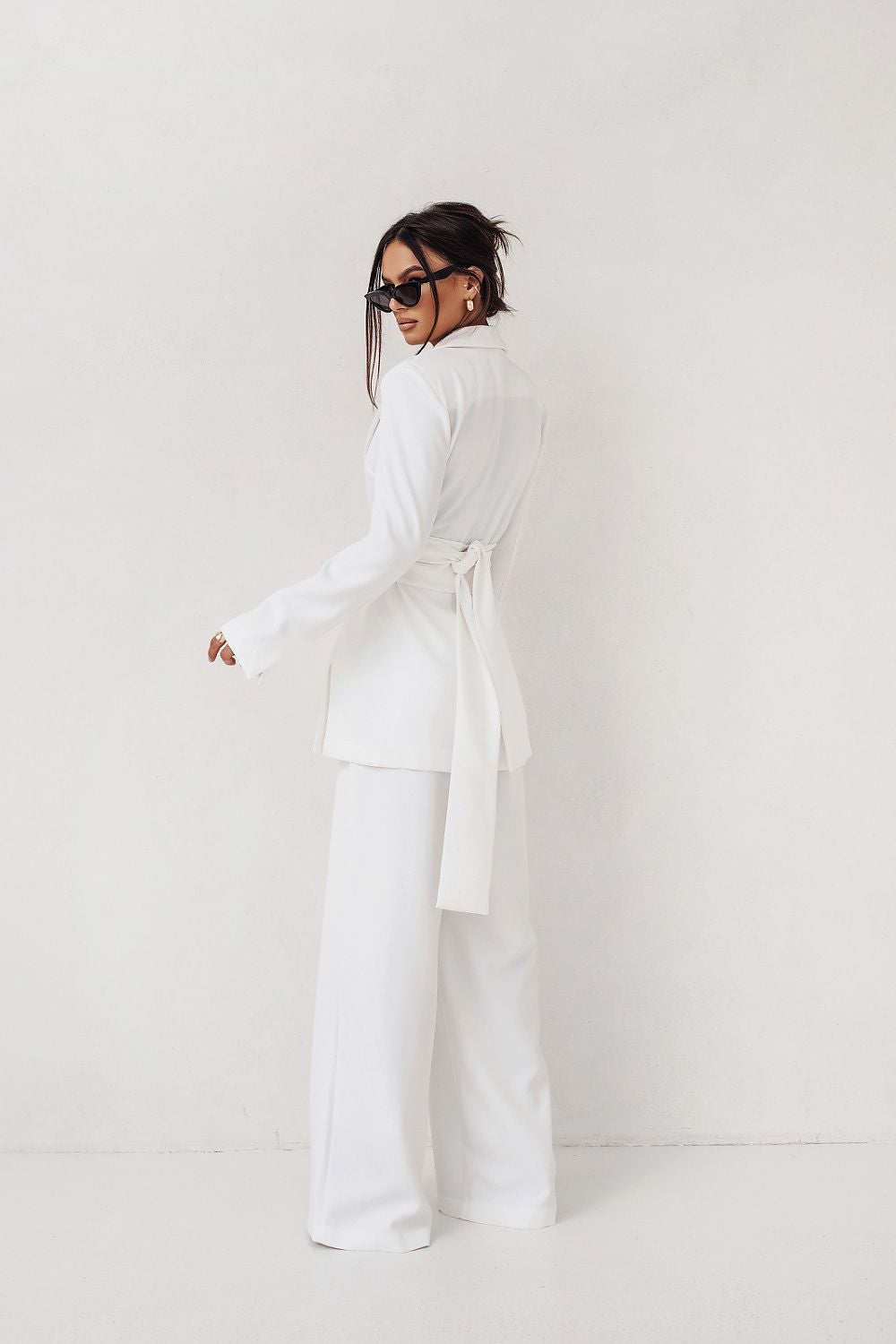 Person wearing a white outfit against a plain background