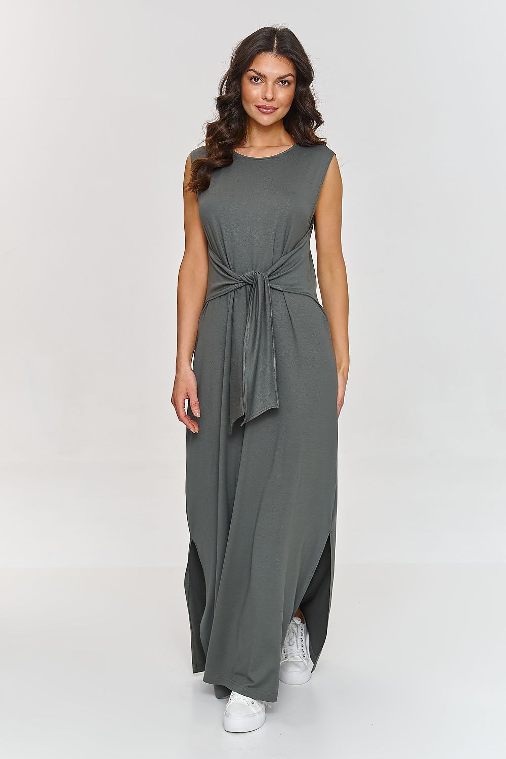 Woman wearing a gray sleeveless dress with a tie waist on a white background