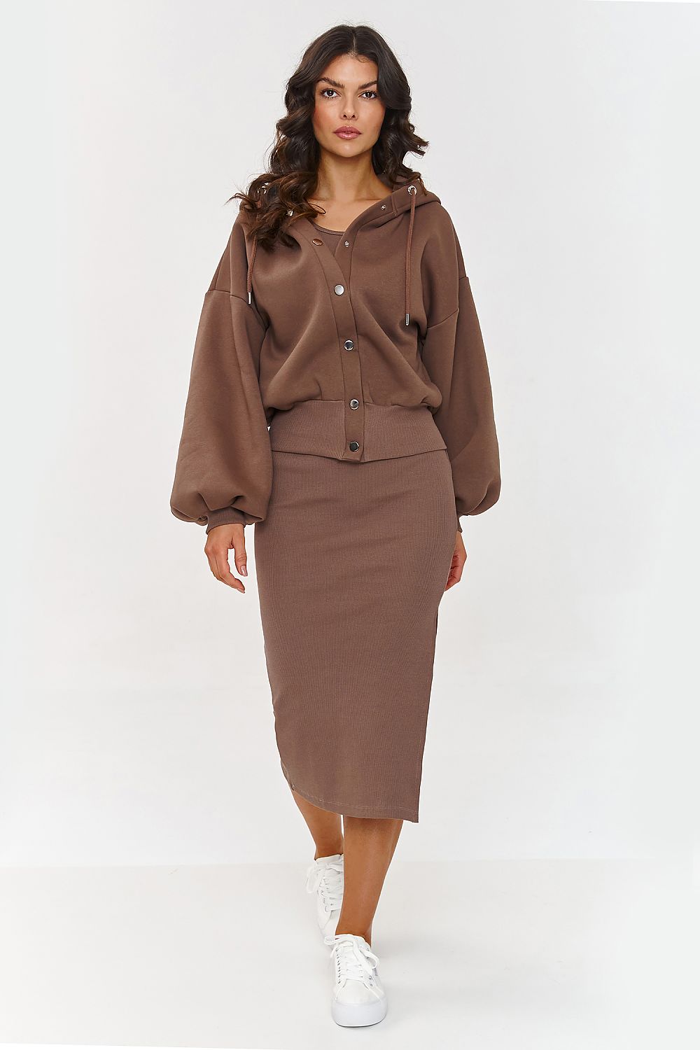 Woman wearing a brown outfit with a jacket and skirt on a white background