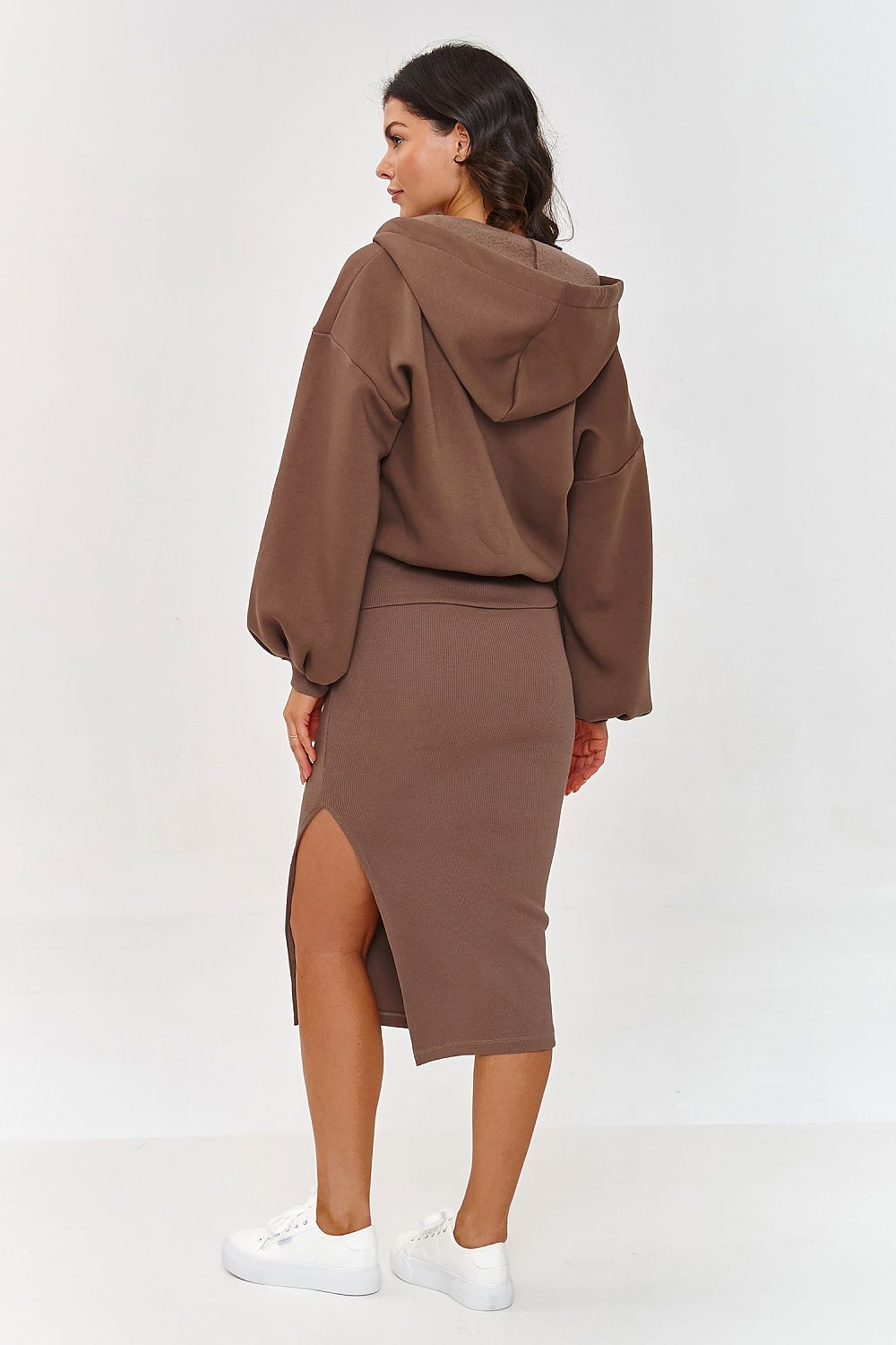Woman wearing a brown hoodie and skirt set on a white background