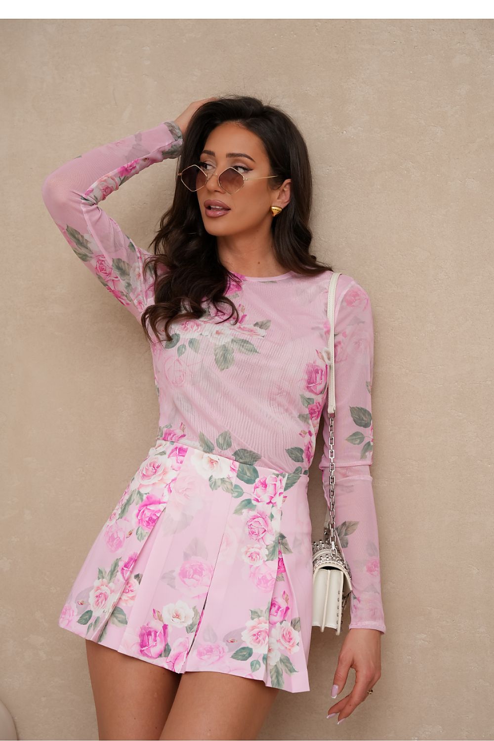 Woman wearing a pink floral dress against a beige background