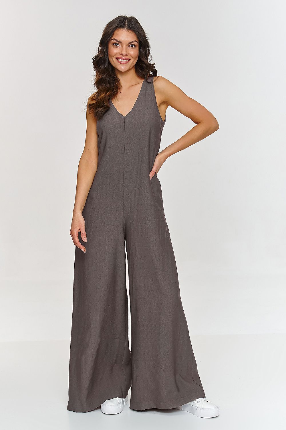 Woman wearing a brown jumpsuit on a white background
