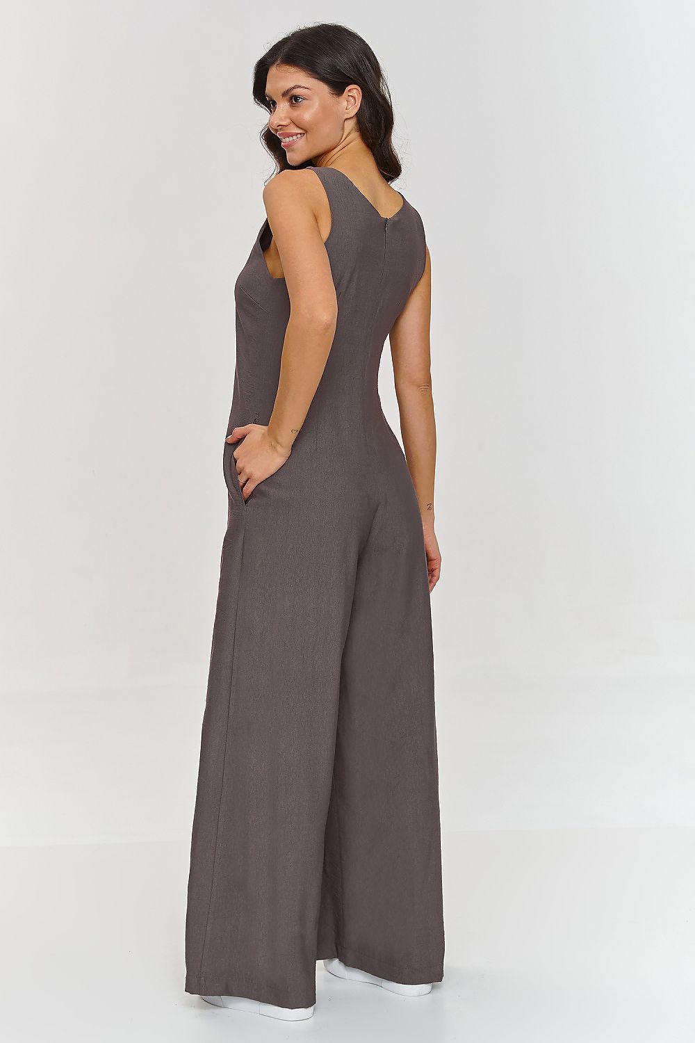 Woman wearing a gray jumpsuit on a white background
