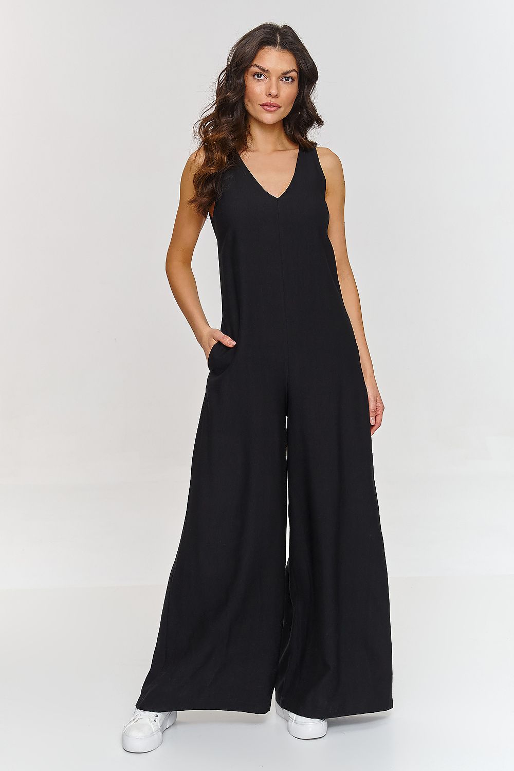 Woman wearing a black jumpsuit on a white background