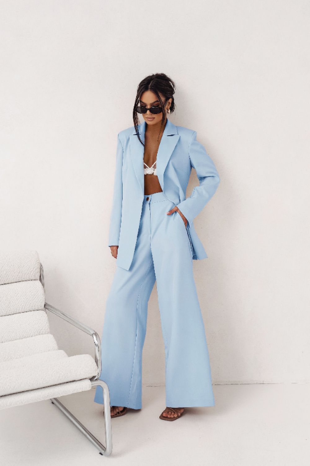 Woman wearing a light blue suit in a minimalistic setting