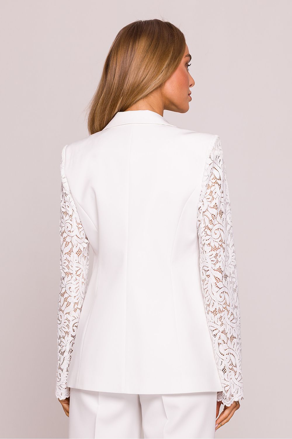 White lace-trimmed jacket worn by a person on a plain background