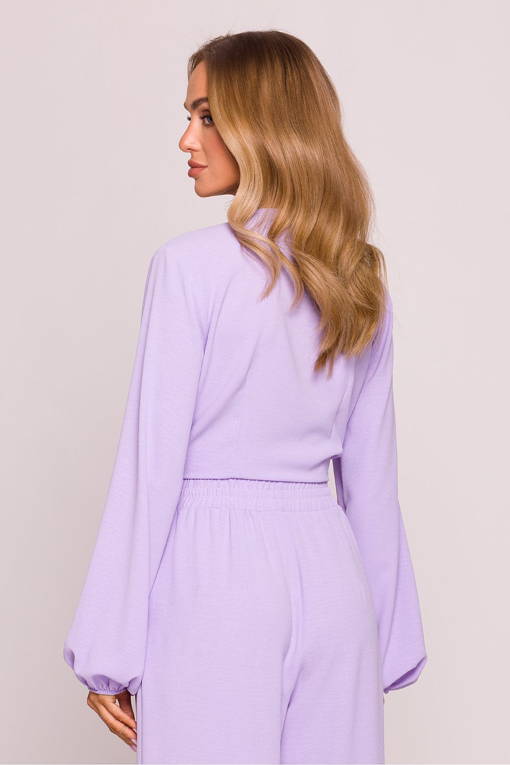 Woman wearing a light purple dress against a plain background