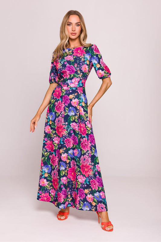 Woman wearing a colorful floral dress on a plain background