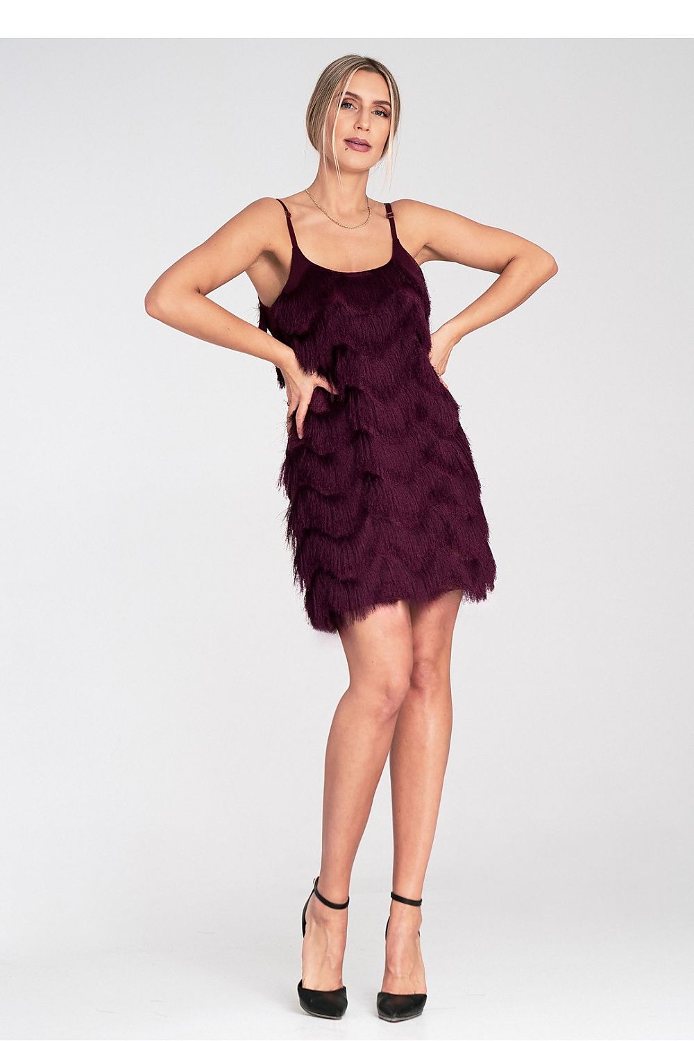Woman wearing a purple dress with ruffled layers on a white background